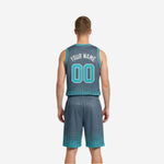 Side view of reversible club basketball uniforms charcoal gray side showing V-neck binding and halftone dot pattern on jersey and shorts hem