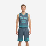 Custom reversible club basketball uniforms in charcoal gray with teal halftone dot fade pattern, arched team name and front number sublimated on the jersey and matching shorts