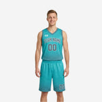 Custom printed reversible basketball uniforms showing the teal side with gray halftone dot fade, gray arched team name and number on jersey and reversible shorts