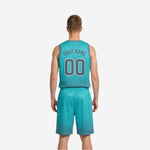 Side view of reversible basketball uniform teal side showing contrast gray binding at V-neck and gray dot fade pattern at shorts hem