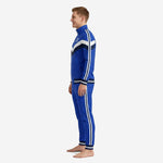 Royal blue soccer tracksuit side angle showing chevron shoulder panel in navy and white with full-zip stand collar and tapered pants