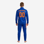 Close-up of orange splash sublimation print detail on royal blue soccer tracksuit jacket chest and pant leg