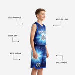 Close detail of royal blue starburst sublimation pattern with cyan light rays star field particles and white contrast trim on youth basketball jersey
