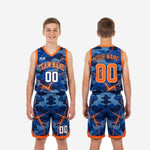 Back view of royal blue camo youth basketball jersey showing player name arc and large back number with orange outline