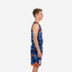 Royal blue youth basketball uniforms with orange camo print and V-notch trim shorts, side view of full 2-piece set on youth model