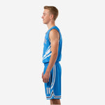 Side view of royal blue youth basketball jersey and shorts showing diagonal white swoosh stripes sweeping across the right panel