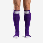 Custom purple soccer socks in Royal Purple with three white contrast stripe bands at the ribbed cuff, front view on adult male model