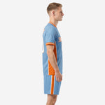 Sky blue and orange custom soccer kit side view showing orange panel running from underarm through shorts