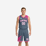 Reversible basketball uniforms with names and numbers in gray and pink brush-splash design, front view showing gray dominant side with V-neck jersey and matching shorts