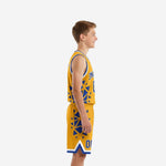 Custom gold youth basketball uniform set showing V-neck jersey with blue geometric panels and matching shorts with white hem band - front view on youth model