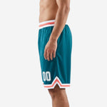 Second side angle of teal sublimated basketball shorts showing coral chevron hem detail and white number placement on lower thigh panel