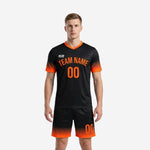 Men's sublimated black soccer uniforms with Athletic Orange gradient on sleeves and shorts hem, front view, custom team name and number on chest