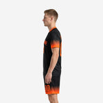 Right side view of sublimated black and orange soccer uniform set showing matching shorts with orange gradient hem and player number