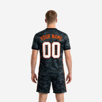 Full-dye sublimated black and orange soccer uniform with team name and number on jersey chest