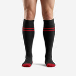 Sublimated red and black soccer socks with double red stripe band and red toe, front view on male model