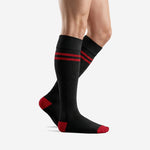 Custom red and black soccer socks showing over-the-calf length and double stripe detail, side view