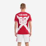Red soccer uniform jersey front detail showing team name and number printed in white within brush-stroke X graphic panel