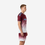 Custom maroon gradient red soccer uniform side view showing continuous fade from shoulder to hem on jersey and shorts