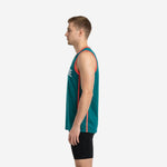 Side view of custom sublimated teal basketball jersey showing coral vertical side panel stripe running from armhole to hem on male model