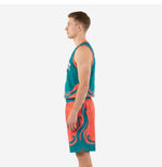 Side view of teal and orange basketball uniform set showing wave graphic continuing from jersey hem down the shorts leg