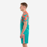 Custom soccer uniform side view in teal and coral with gradient jersey fade and side stripe shorts