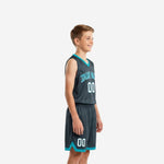 Side view of charcoal and teal youth basketball uniform showing V-neck jersey and matching shorts with teal hem trim on a youth boy