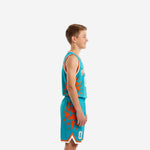 Front view of custom teal youth basketball uniform with arched team name, number 00, and orange geometric shard panels on jersey and shorts