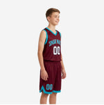 Maroon and teal youth basketball uniform front view showing arched team name across chest, front number, and teal armhole binding