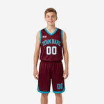 Custom teal youth basketball uniforms in maroon and teal showing full two-piece set with V-neck jersey and matching shorts, front view