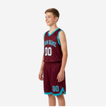 Side view of custom teal youth basketball uniforms showing maroon jersey body, teal V-neck and armhole binding, and matching shorts