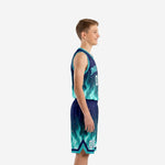 Side view of custom teal and navy youth basketball uniform set showing flame graphic on jersey hem and shorts leg opening