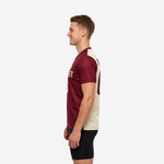 Right side view of a custom red soccer training jersey in maroon and cream showing the back panel split and rear number placement