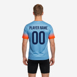 Back view of custom v neck soccer training jersey in sky blue with orange sleeve gradient, showing back number and name print zone