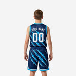 Blue and white youth basketball uniforms navy and cyan claw-mark pattern, opposite side profile showing shorts waistband drawcord detail