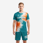 Close detail of vivid teal and orange custom soccer jersey showing sublimation print quality and white collar trim