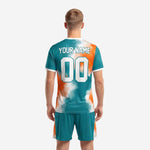 Back view of vivid teal and orange custom soccer uniforms with player name and number print zones
