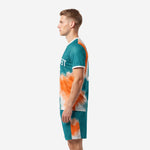 Men's vivid teal and orange custom soccer uniforms side view showing splash pattern on jersey and shorts
