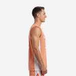 Adult male wearing custom white and orange basketball jersey with orange body panel and white contrast side panels on gray background