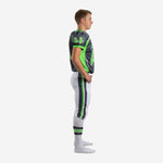 Side view of custom white youth football uniforms showing neon green chest panel, set-in sleeve, charcoal shoulder panel and white pants with charcoal green side stripe