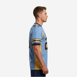 Custom light blue and navy football jersey with arched team name, front number 23, and gold sleeve stripes - front view on male model