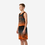 Side view of custom black and orange youth basketball uniform set showing honeycomb pattern on jersey and shorts with orange V-neck and armhole trim