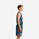 Custom teal youth basketball uniform set with coral V-neck, arched team name, and player number on the jersey front