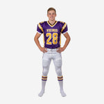 Youth football uniform sets for teams in purple and gold - sublimated V-neck jersey with front number 28 and white football pants with purple gold leg stripe