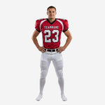 Youth football uniforms in red and white with black trim, front view showing team name and number 23 on the jersey and full-length white pants with red side stripe