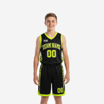 Youth tournament basketball uniforms in black and neon lime with diagonal slash side panels, arced team name and number on jersey and shorts - front view