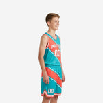 Teal and coral custom youth travel basketball uniforms front view showing arced team name, front number 00, and V-neck binding detail